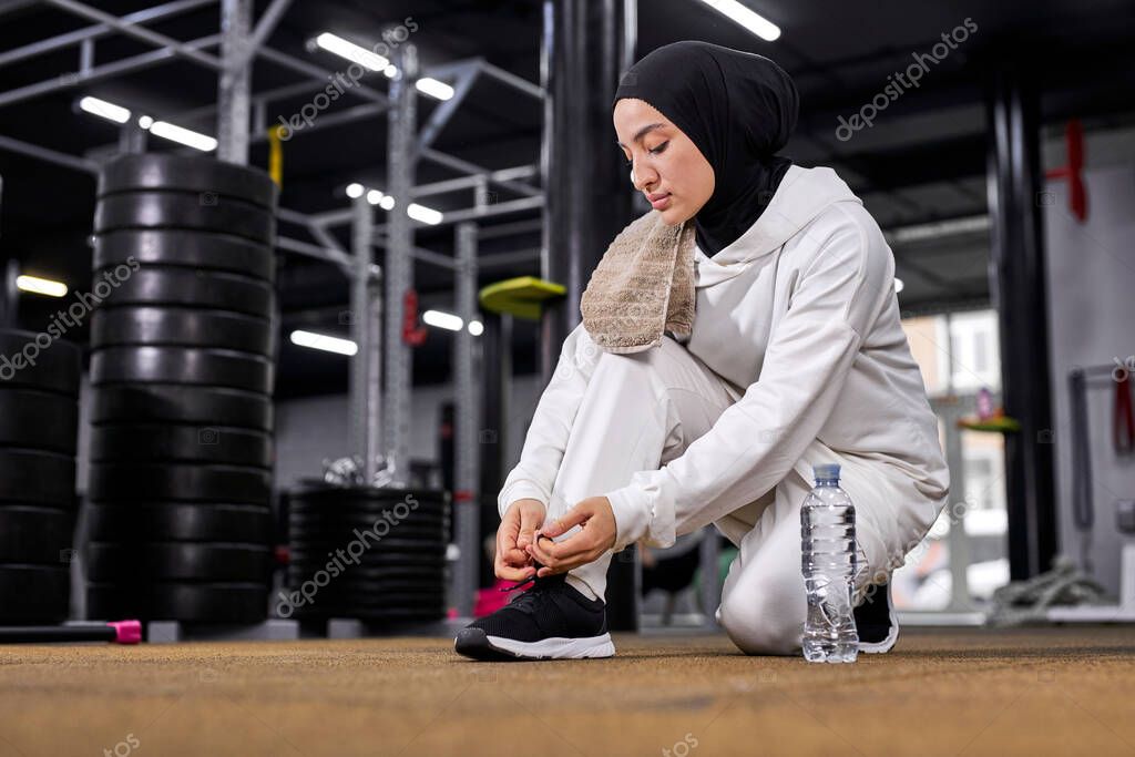 muslim sportswoman tie the laces on the sneakers