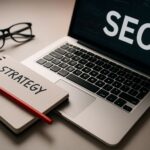Tampilan ruang kerja profesional dengan laptop dan aksen merah menggambarkan strategi SEO generatif yang relevan dengan ekspansi AI Overviews di lebih dari 200 negara.