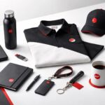 Bahan ramah lingkungan seragam dan jersey: tumpukan kain eco-friendly dengan aksen merah–hitam, tampilan minimalis, soft lighting, tanpa manusia.